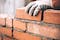 person stacking bricks as an eco-friendly construction option for civil engineering